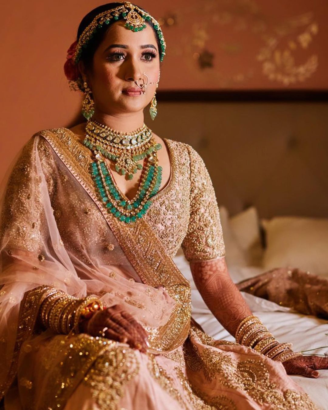 Photo of Sikh bride with peach lehenga and green jewellery